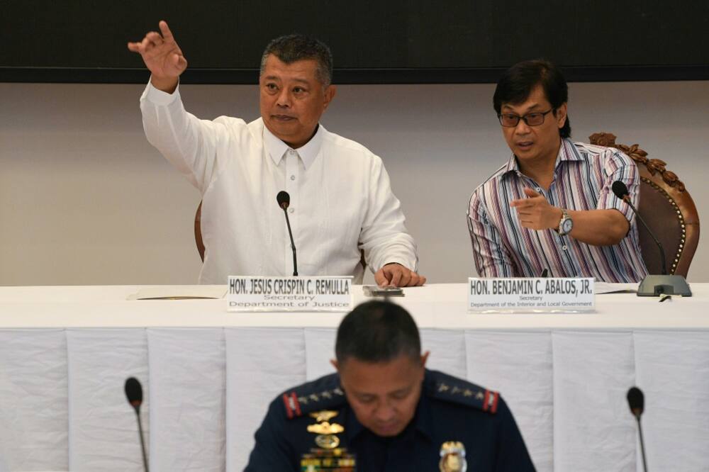Philippine officials, pictured, give a press conference announcing that the country's prisons chief is accused of a journalist's murder