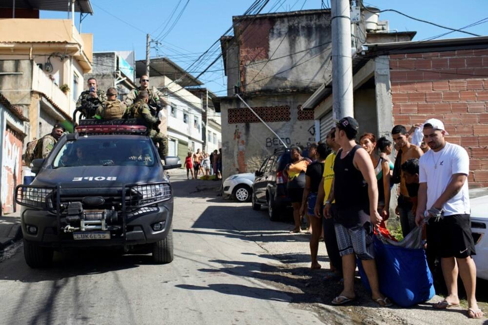 Residents of the Complexo do Alemao favela in Rio de Janeiro carry the body of a man who was killed in a police raid on July 21, 2022