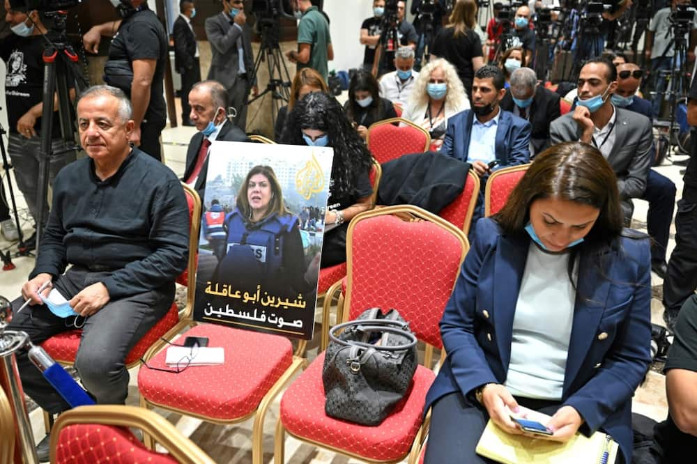 A photo of slain US-Palestinian Al Jazeera correspondent Shireen Abu Akleh, with a caption in Arabic calling her "the voice of Palestine", is seen amongst reporters ahead of a joint press conference between the US and Palestinian presidents