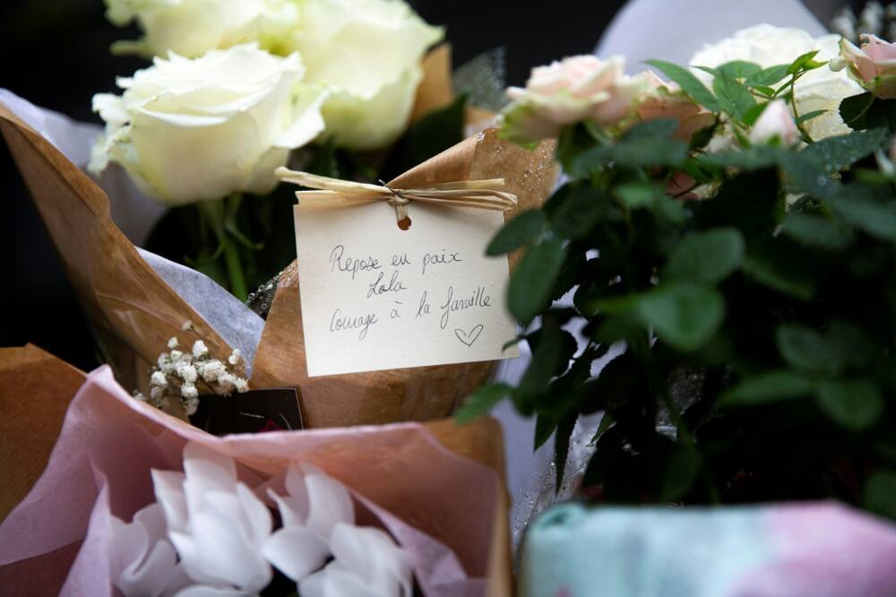Locals left bunches of flowers with a hand-written message which reads "Rest in peace Lola, courage for the family", displayed outside the building where the 12-year-old disappeared