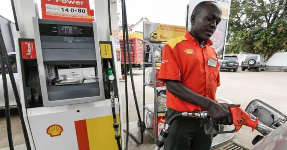 A pump attendant fills the tank of a car at a petrol station on September 4, 2018.