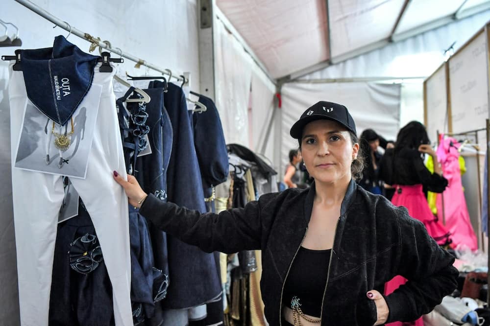 French fashion designer Maud Beneteau poses for a photograph with her designs backstage during a fashion show at Tunisia's Carthage Museum for the launch of Outa