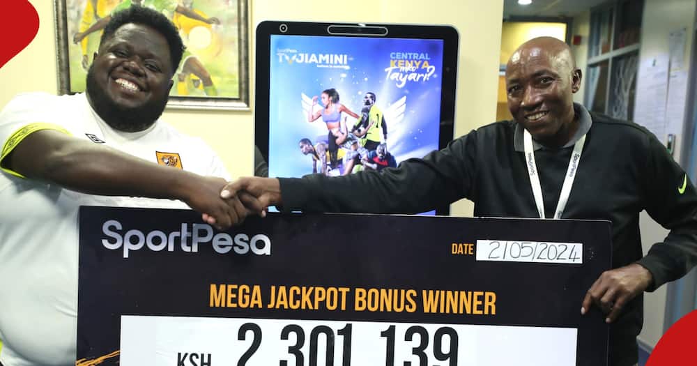 A Kenyan punter receives a cheque after winning a jackpot bonus.