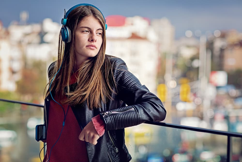 A girl is listening to music on the rooftop