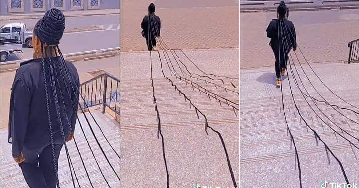 Lady sweeps floor with long braids, extremely long.