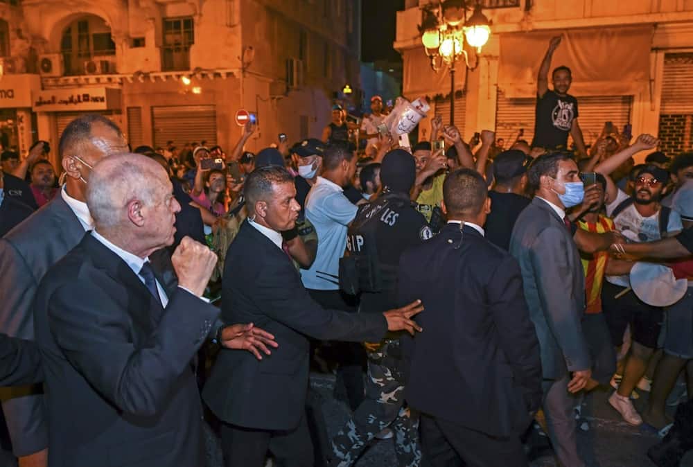 President Kais Saied raises a fist in celebration with his supporters