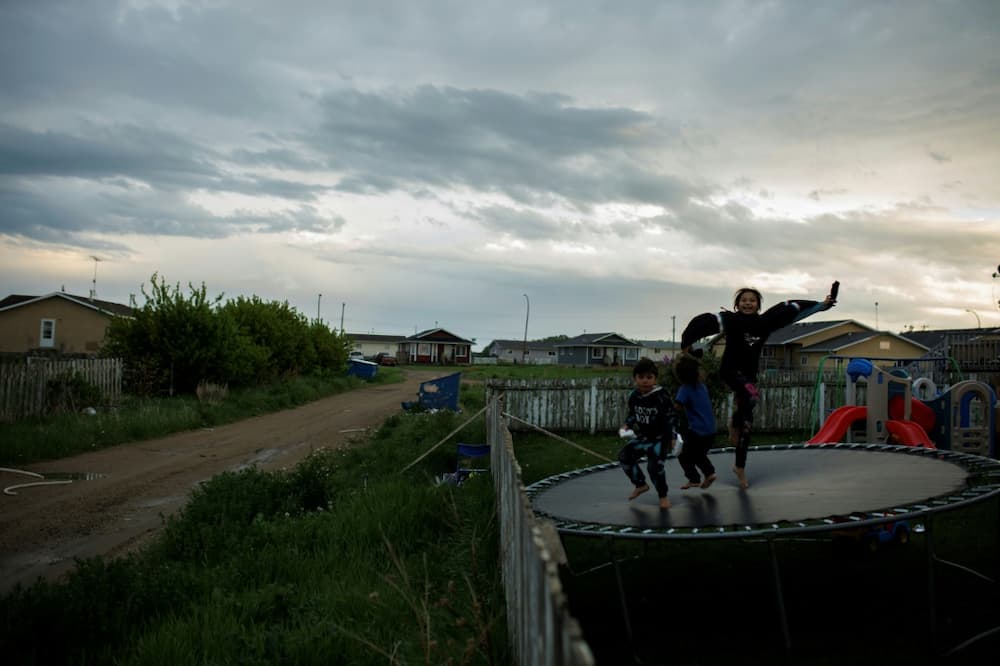 Children on June 7 play on a trampoline in a backyard in the Indigenous community of Maskwacis, Alberta, where Pope Francis is to make a stop during his upcoming visit to Canada
