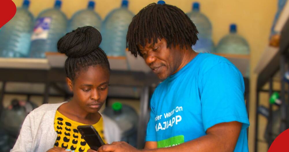 Erick Oduor shows a female customer how MajiApp works.