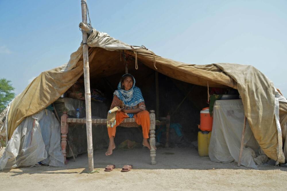 A woman shelters under a tarpaulin in Dera Allah Yar, Balochistan province