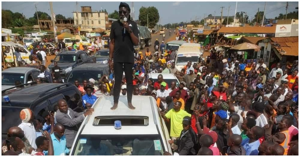 Man in black standing on car