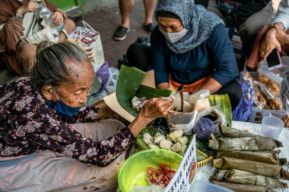 Septuagenarian Mbah Satinem (L) charges 10,000 rupiah ($0.67) for a serving of the lupis her mother taught her to make