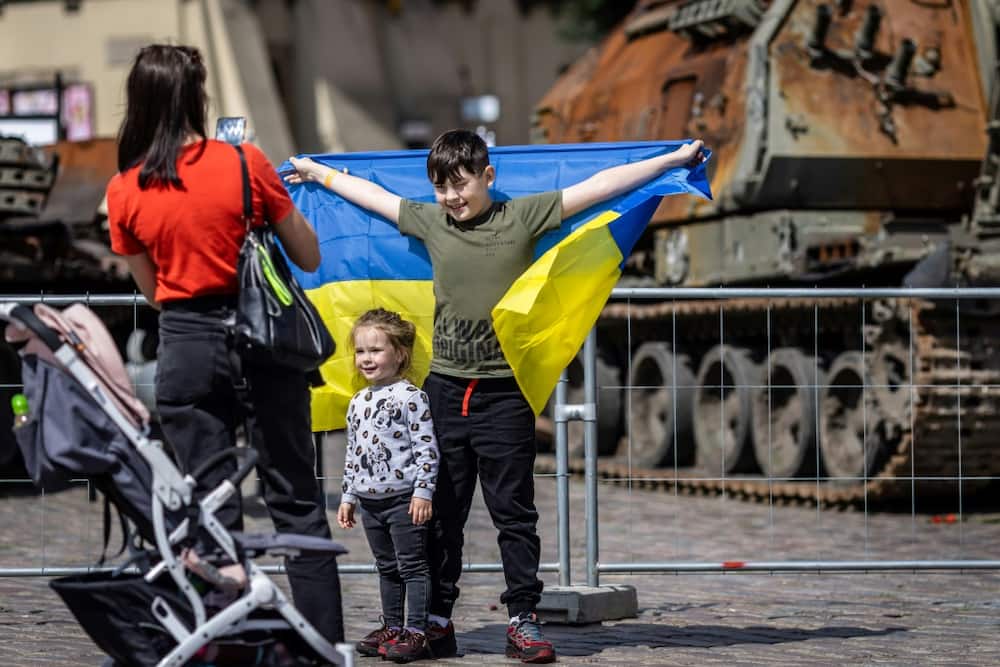 Ukrainian children pose in front of the tanks. Poland has welcomed more than 4.5 million Ukrainians since the invasion