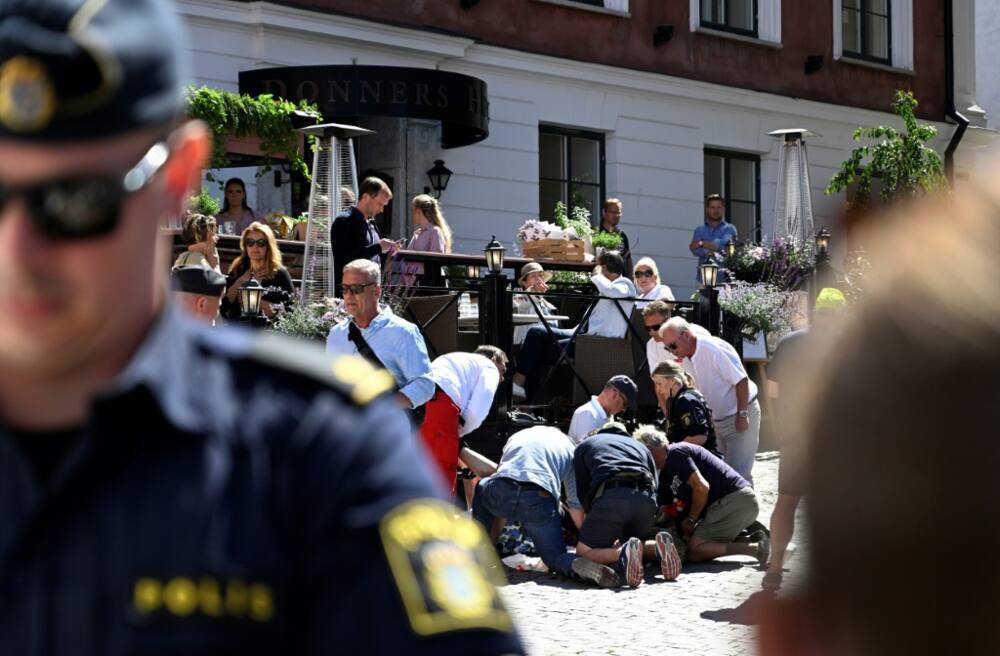 Police and rescue services give medical aid to a woman who was seriously injured in a stabbing at the Almedalen political festival in Visby on the Swedish island of Gotland on July 6, 2022