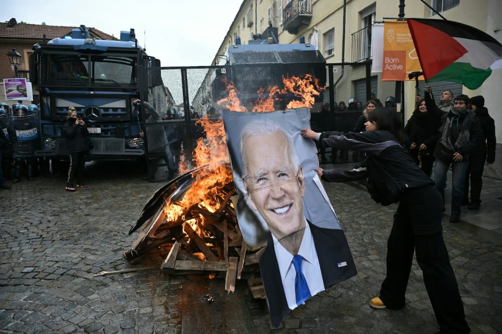 Activists burn a portrait of US President Joe Biden and G7 leaders during a demonstration against the G7 Climate, Energy and Environment held in Turin, on April 28
