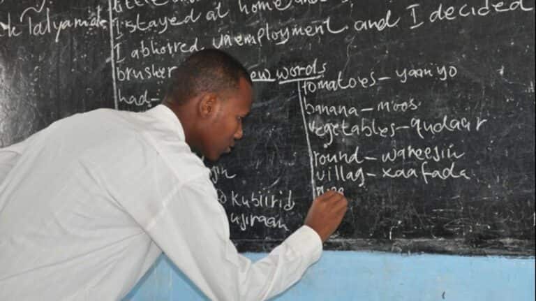 A teacher writing on the blackboard