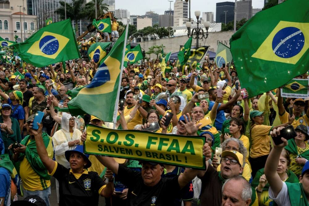 Supporters of Brazilian President Jair Bolsonaro hold signs asking for military intervention during a demonstration against the results of the runoff election which he lost to Luiz Inacio Lula da Silva