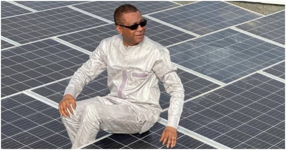Youssou N'Dour sitting on solar panels.