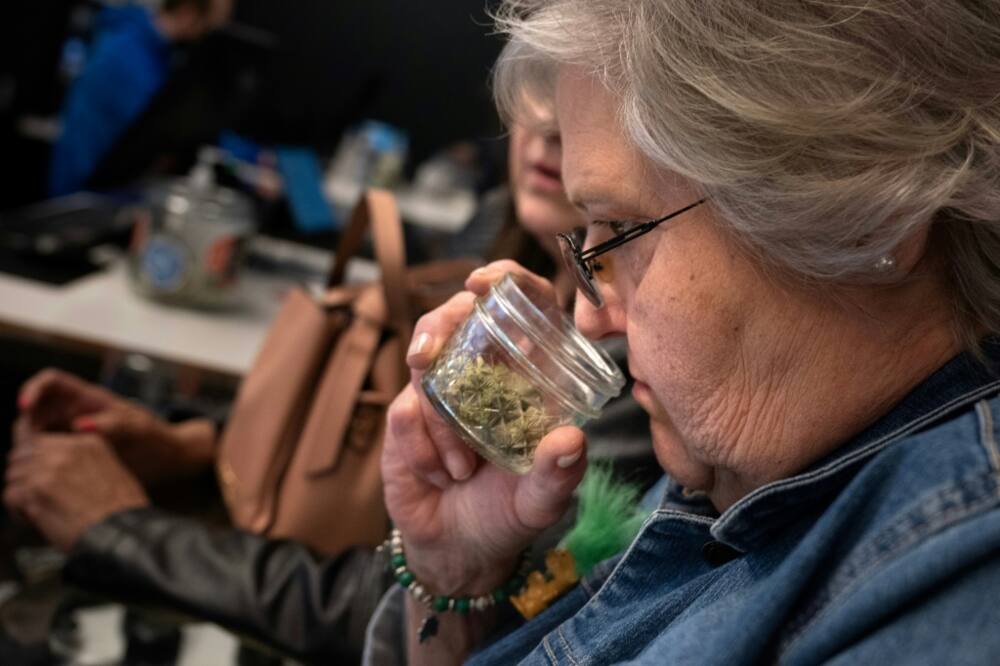 Juree Burgett, who traveled from Kansas, smells various varieties of cannabis at a dispensary in Kansas City, Missouri -- a state where recreational pot use is now legal