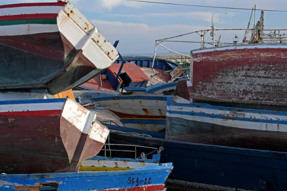 Piles of captured migrant boats are seen in the central Tunisian port city of Sfax on October 4