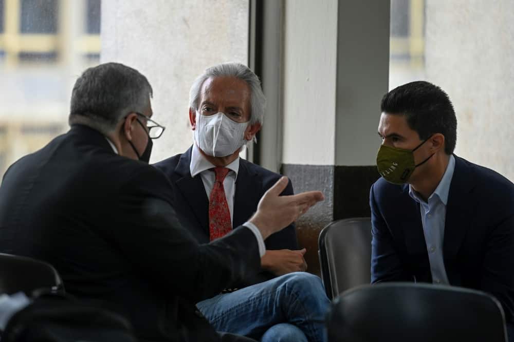 Guatemalan journalist Jose Ruben Zamora (C), president of the newspaper El Periodico, speaks to his lawyer (L) and his son Jose Zamora, during a break in his hearing at the Justice Palace in Guatemala City, on August 8, 2022