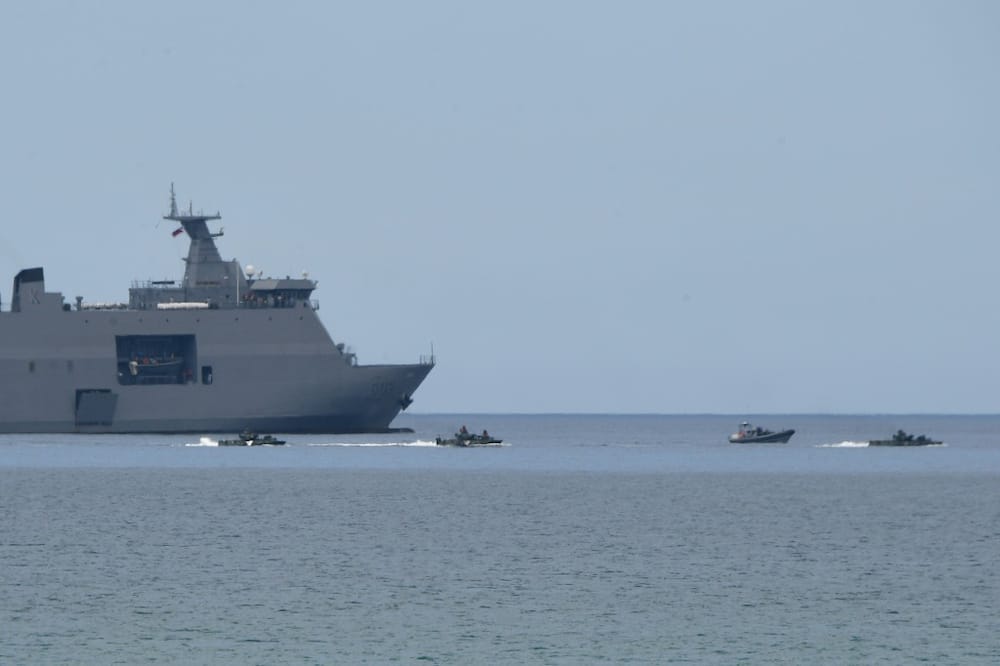 Philippine amphibious assault vehicles manoeuvre next to a BRP Tarlac navy landing platform dock ship