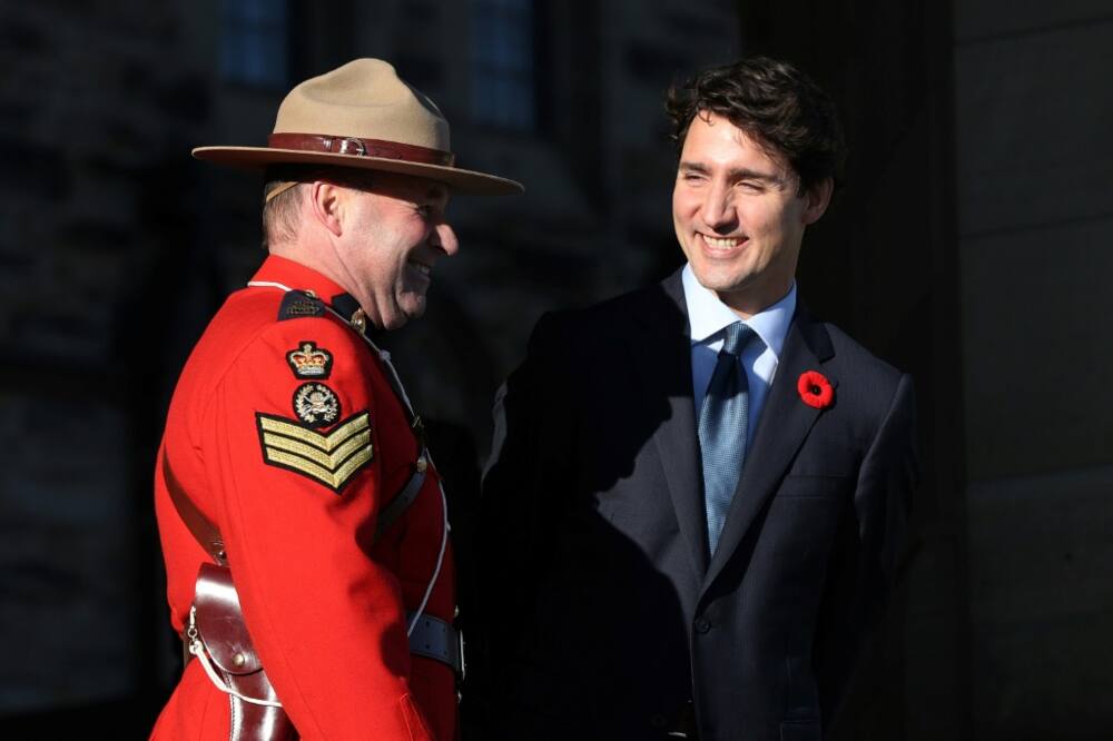 Canadian Prime Minister Justin Trudeau, shown here speaking with an RCMP officer in October 2017, expressed dismay over a contract with a Beijing-linked firm to supply the RCMP anti-eavesdropping radio technology