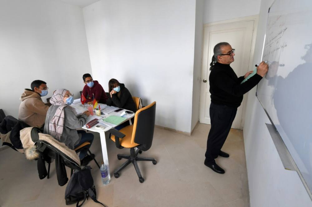 Tunisian Yeft Benazzouz (R), who runs a language school in the capital Tunis, teaches a class German