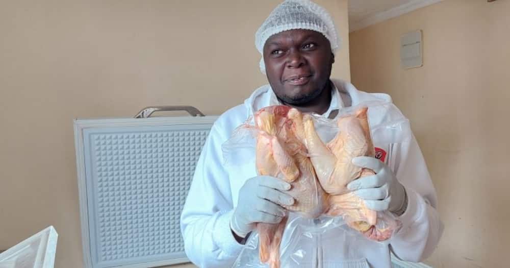 Meshack Mwau holds an improved kienyeji chicken.