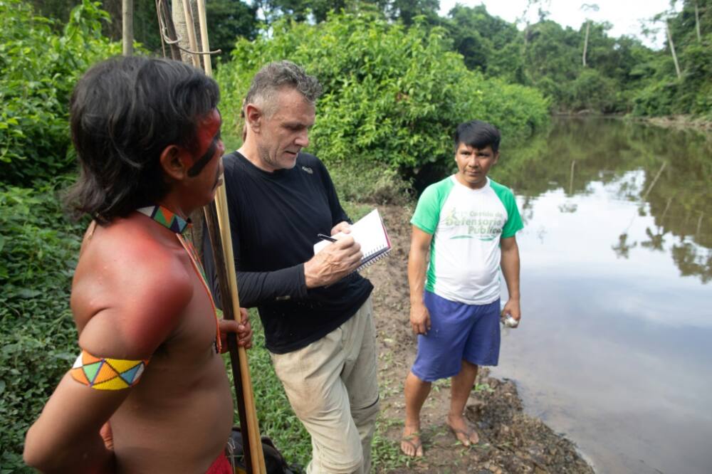 Veteran foreign correspondent Dom Phillips (C) talks to two indigenous men in Brazil in 2019