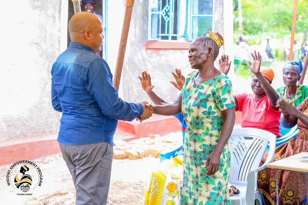 Siaya widow Zainabu Anyango Otieno (r) shakes hands with Victor Ayugi (l).