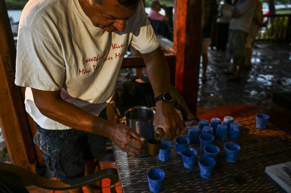 A member of the Royal Naval Tot Club pours rum at the waterfront Galley Bar in Antigua and Barbuda on September 17