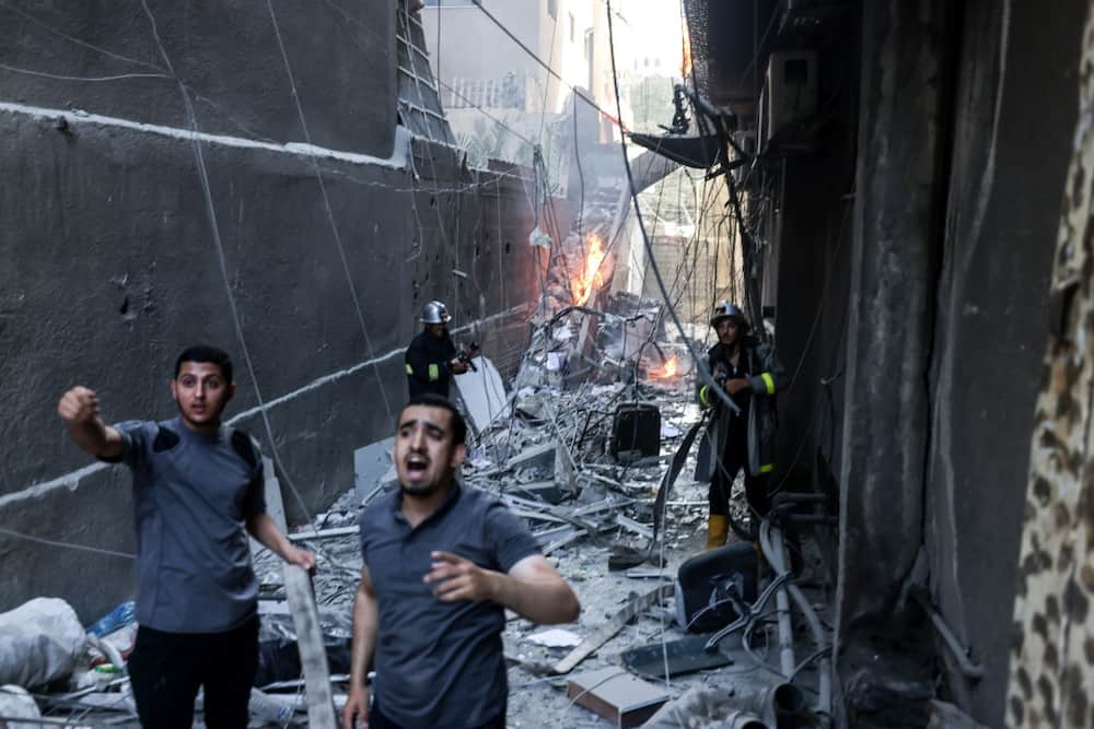 Palestinian firefighters battle a blaze sparked by an Israeli air strike on Gaza City