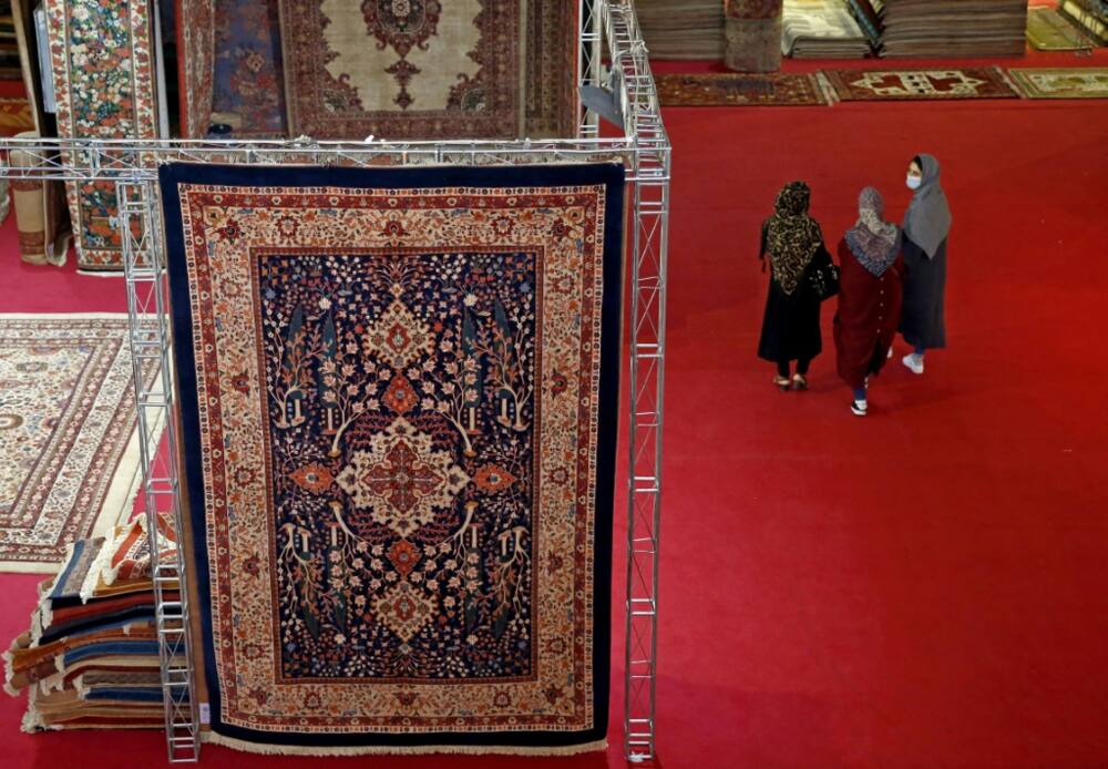 Visitors pass a traditional Iranian carpet design at the 29th Handmade Carpet Exhibition in Tehran