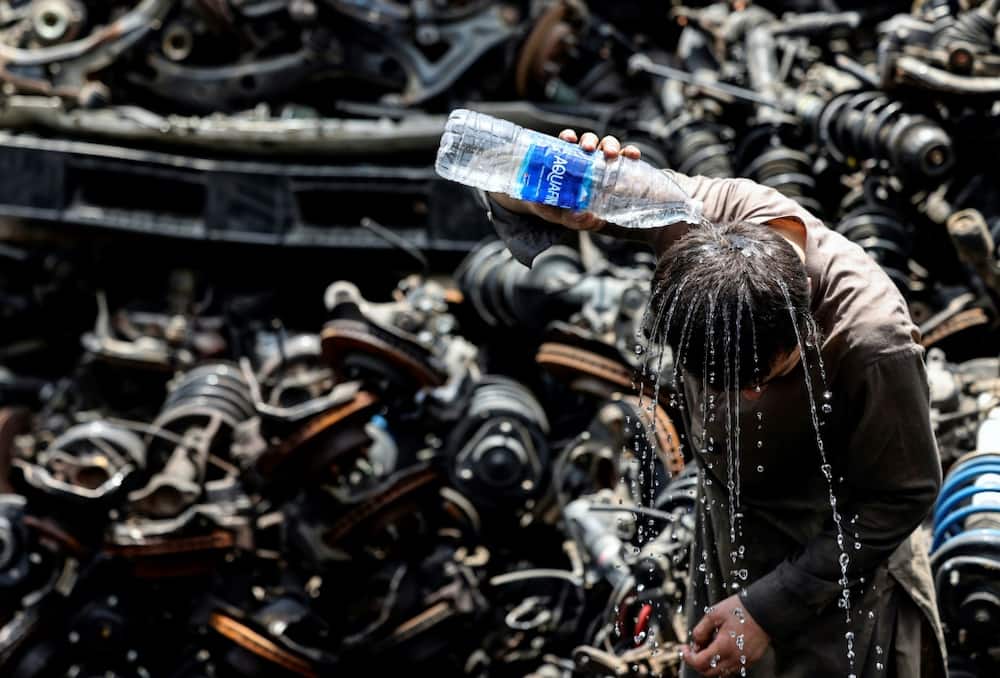 A migrant labourer at a used car parts lot in the UAE emirate of Sharjah tries desperately to cool down amid the sweltering heat