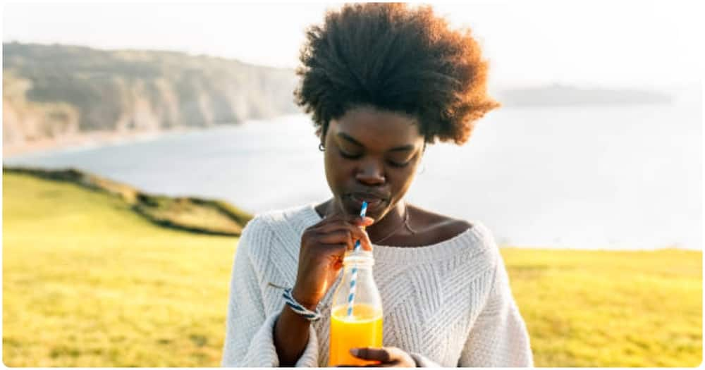 A woman drinks juice.