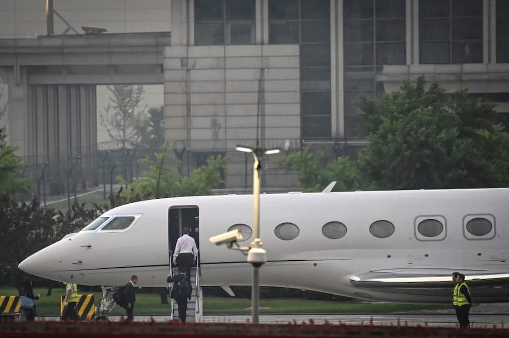 Tesla chief Elon Musk (in white) boards his private jet before departing Beijing Capital International Airport on May 31