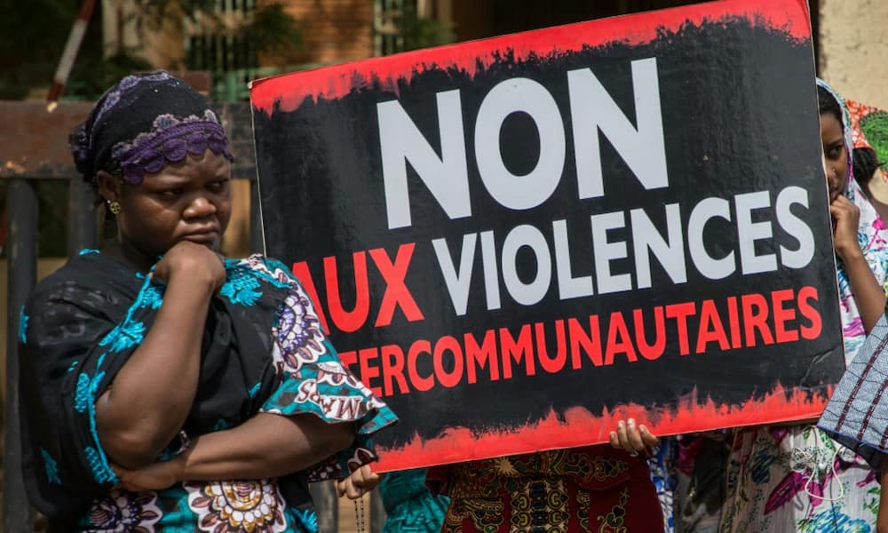 Women hold a sign reading 'No to intercommunity violence' after Fulani villagers in northern Burkina Faso were massacred in 2019 reprisal for a jihadist attack