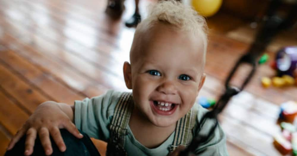 Baby smiling with a background of toys. Photo for illustration.