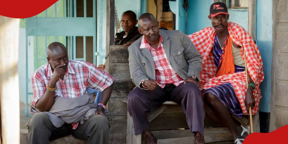 Four African men sitting in front of a house. Street scene in Talek on May 17, 2017 in Talek, Kenya.