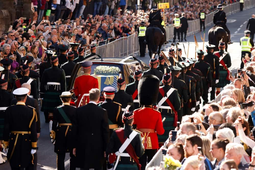 Charles, flanked by his three siblings, led a procession on foot carrying the queen's body through hushed Edinburgh streets packed with mourners