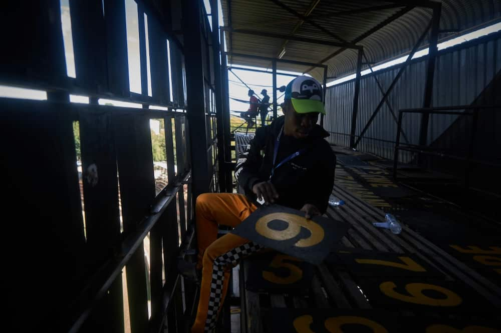 Scoreboard operator Zenzele Ndebele swaps numbers from within the manual scoreboard at Queens Sports Club in Bulawayo