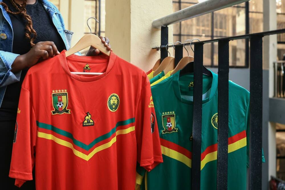 Racks of out-of-date Indomitable Lions shirts with the Coq Sportif logo await customers in a Yaounde sports shop