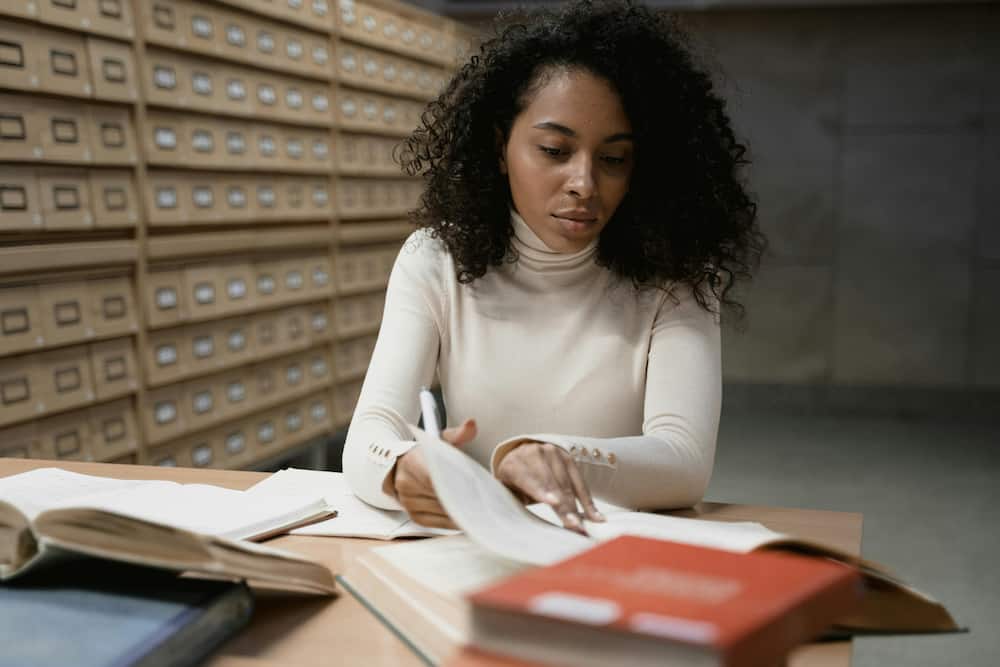 A young woman in a white top is studying