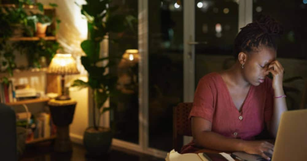 Woman looking down at her laptop deep in thoughts.