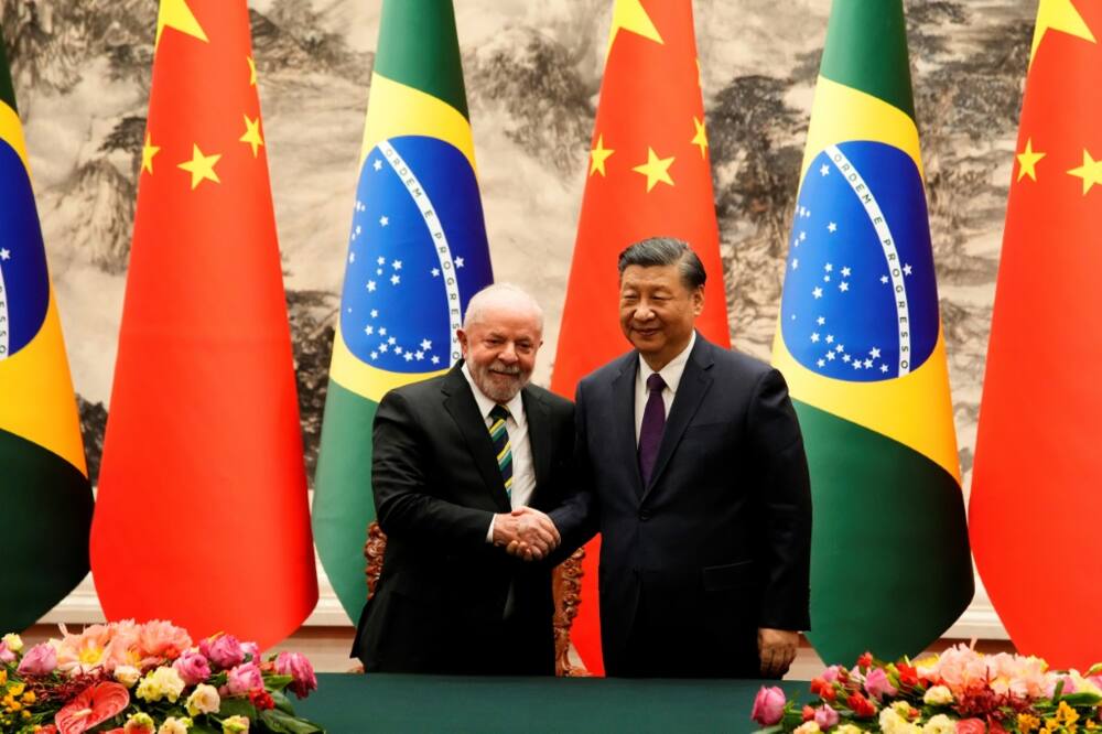 Chinese President Xi Jinping (R) and Brazil's President Luiz Inacio Lula da Silva shake hands after a signing ceremony at the Great Hall of the People in Beijing