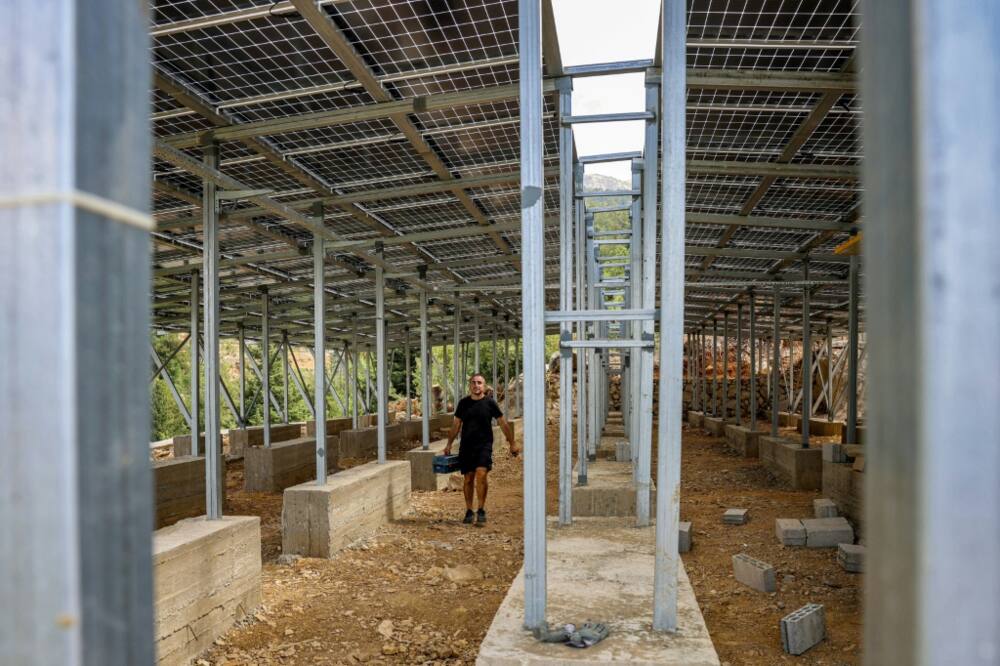 A technician works on the solar panel system installed for the village of Toula in northern Lebanon