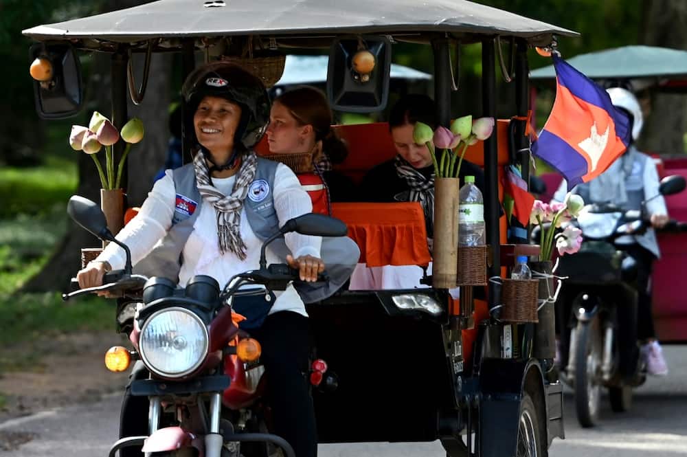 Tuk-tuk driver Kim Sokleang transporting  passengers near the Bayon temple at the Angkor complex in Siem Reap province