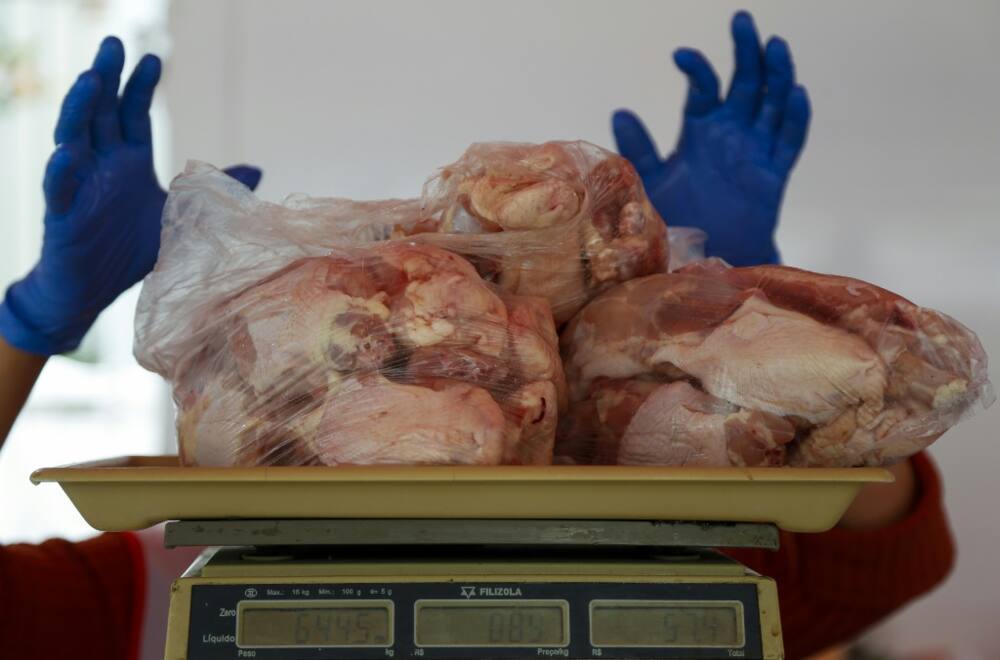 A salesperson weighs chicken at a street market in Sao Paulo, Brazil, on August 25, 2022