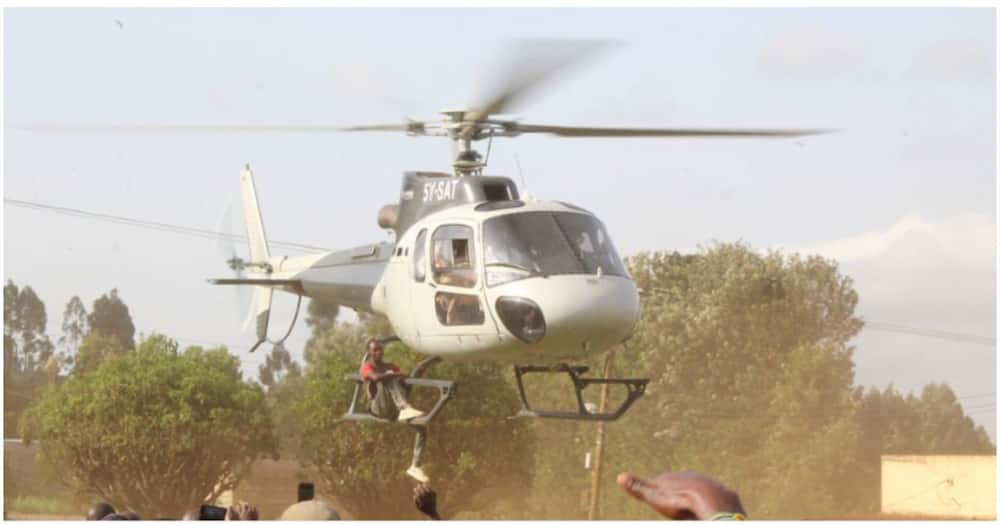 Joakim Mutwiri hung on the landing skids of Agriculture CS Peter Munya's chopper.