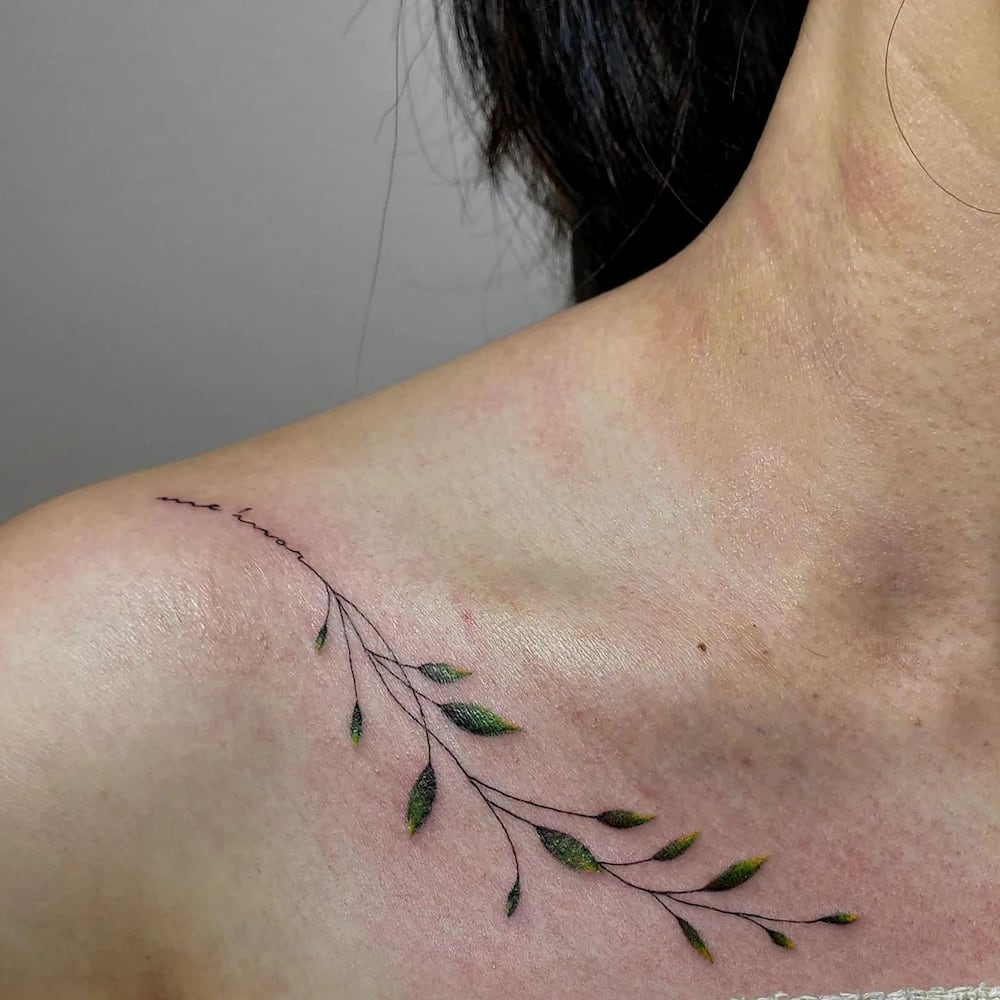 Shoulder of woman featuring minimalist leaf tattoo.